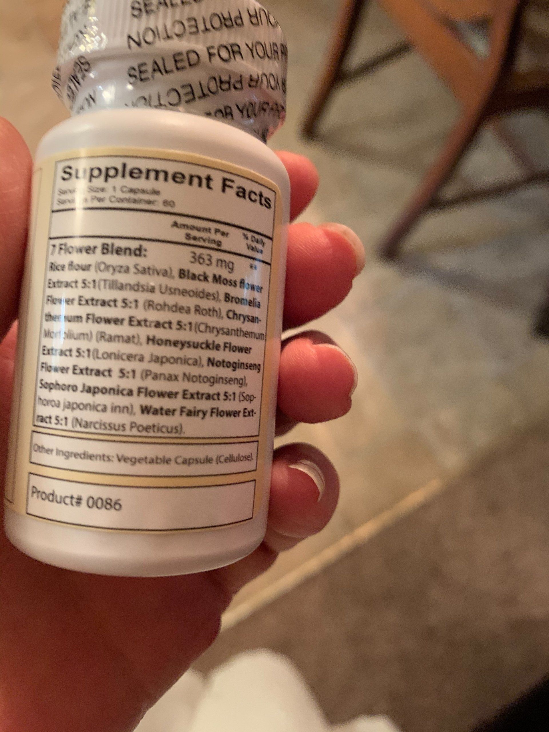 A person is holding a bottle of supplement facts