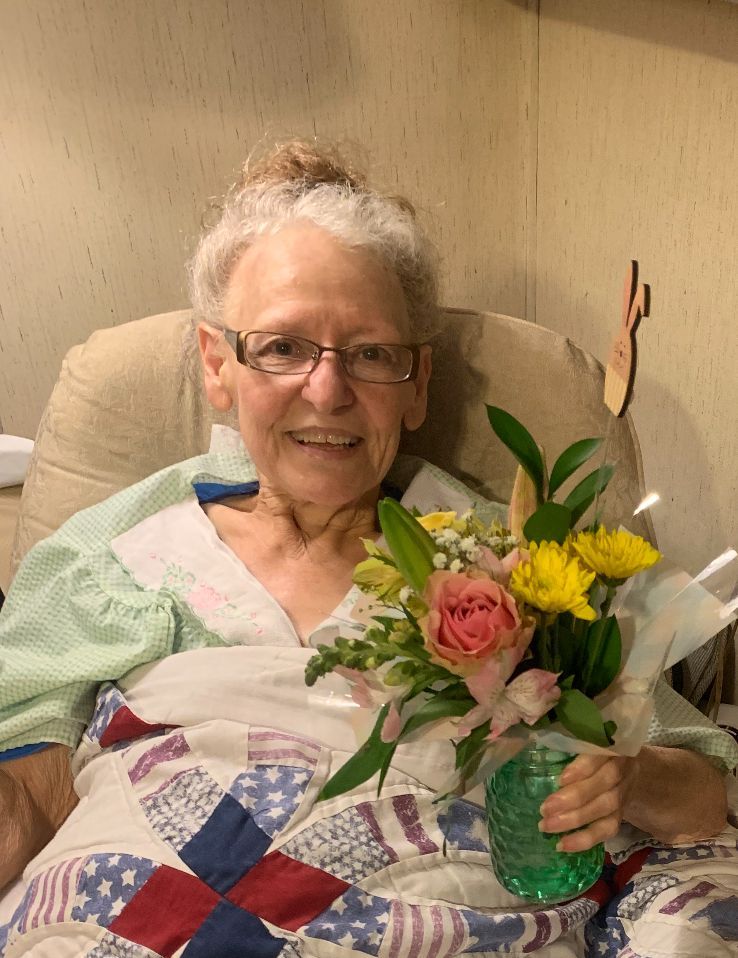lady holding flowers with blanket covering lap