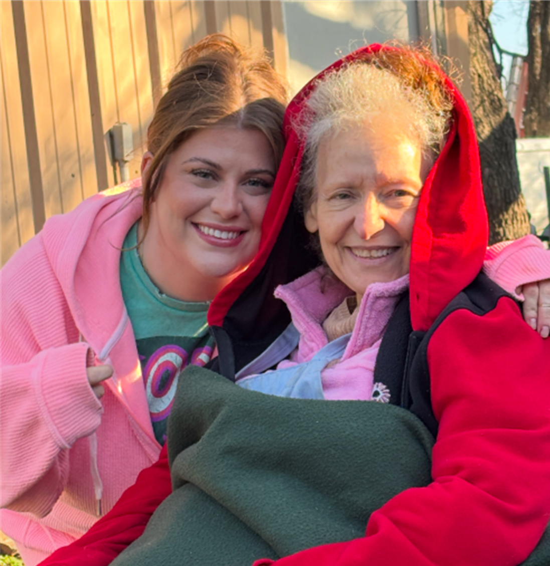 2 ladies sitting bundled up in sunshine