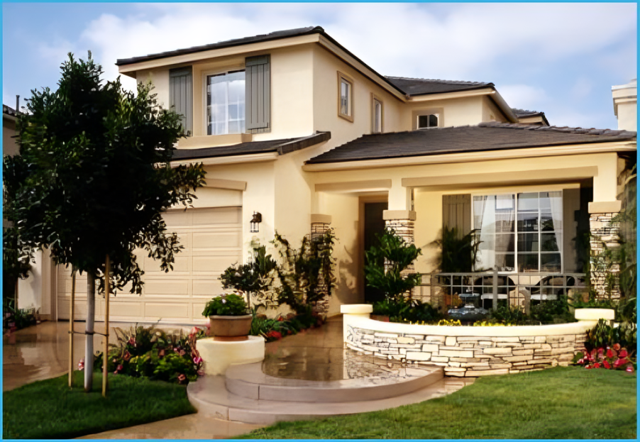 Two-story beige house with manicured lawn, stone accents, and front porch with seating area.