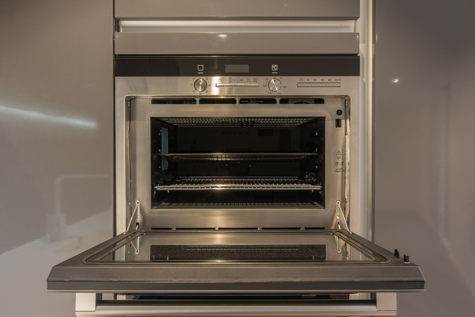 Open microwave oven with stainless steel interior and drop-down door.