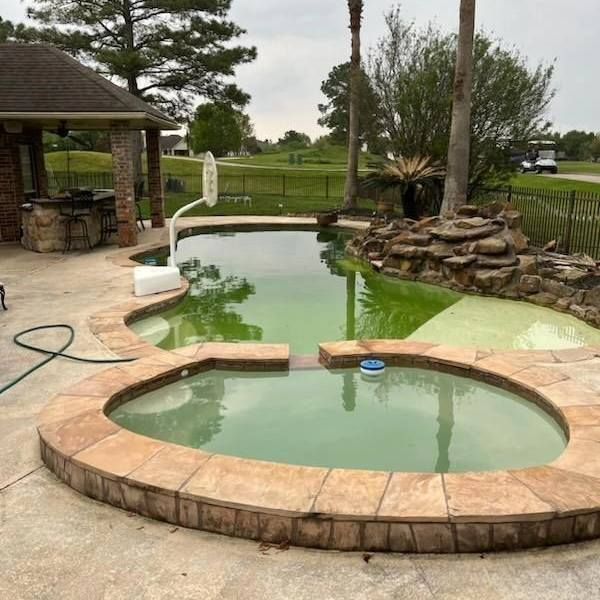 Backyard pool with a small round spa, stone deck, and gazebo beside a larger green-tinted pool.