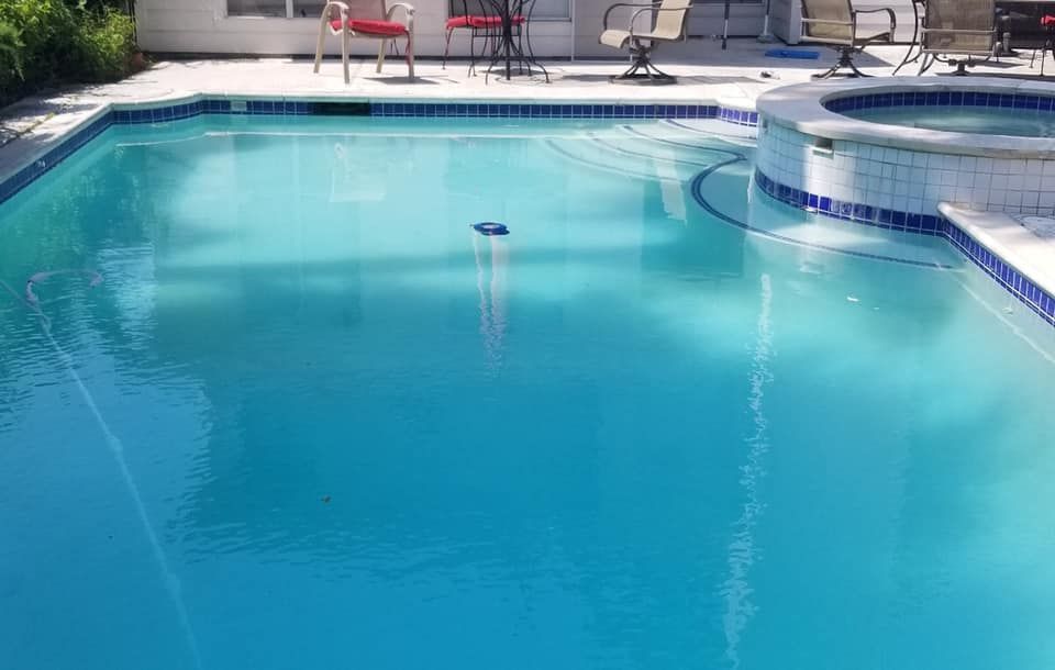 Outdoor swimming pool with bright blue water and white tile coping