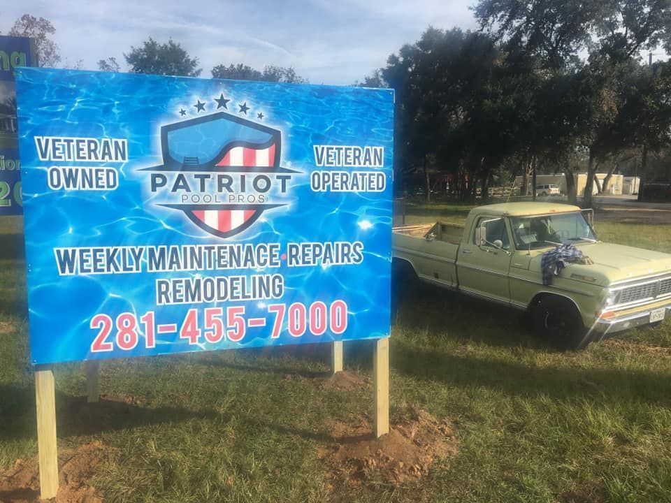 Blue Patriot handyman sign beside a green car on grass, advertising weekly maintenance repairs and remodeling.