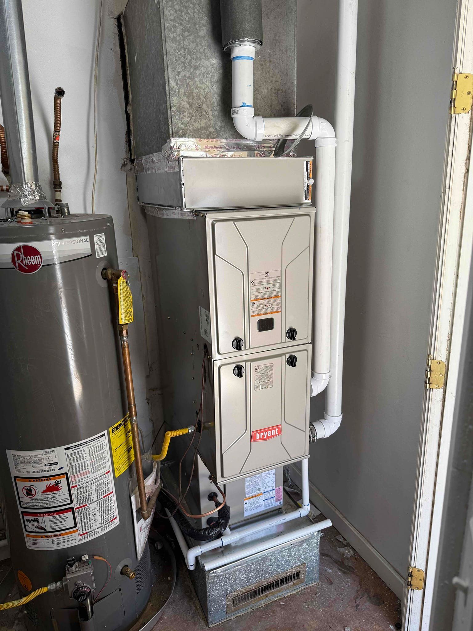 Basement utility room with water heater, furnace, and white plumbing pipes