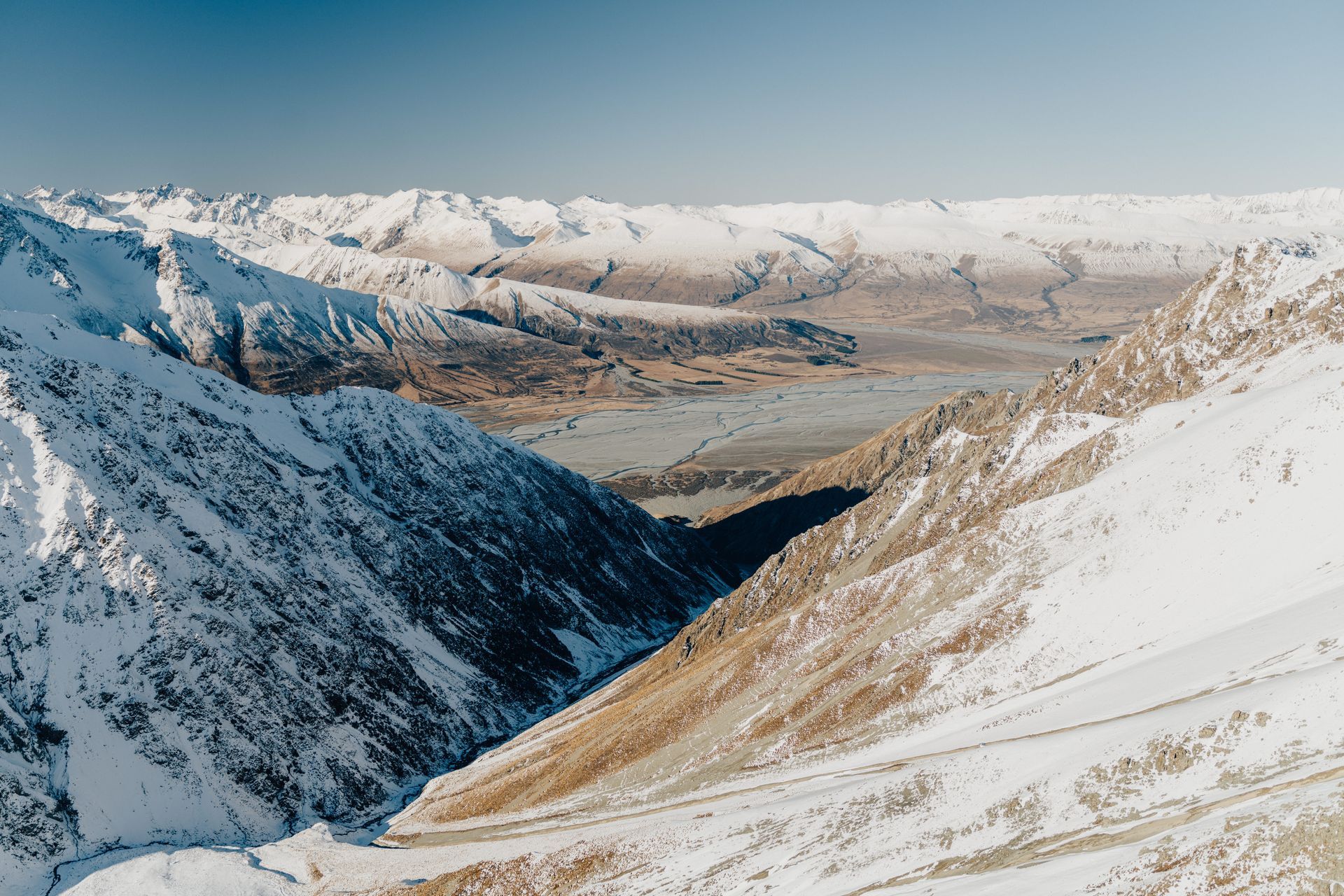 A snowy mountain range with a lake in the middle of it