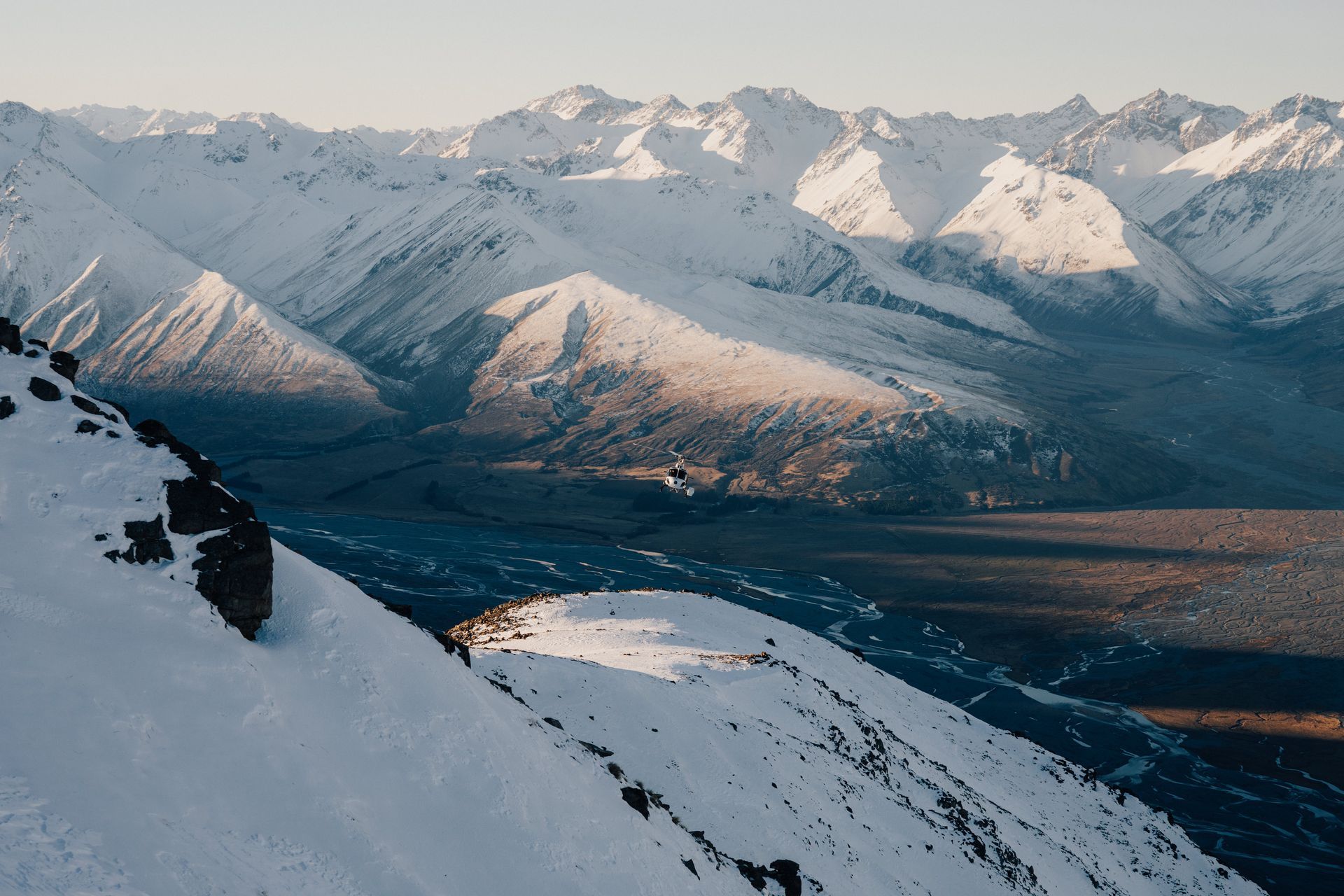 A snowy mountain range with a lake in the middle of it