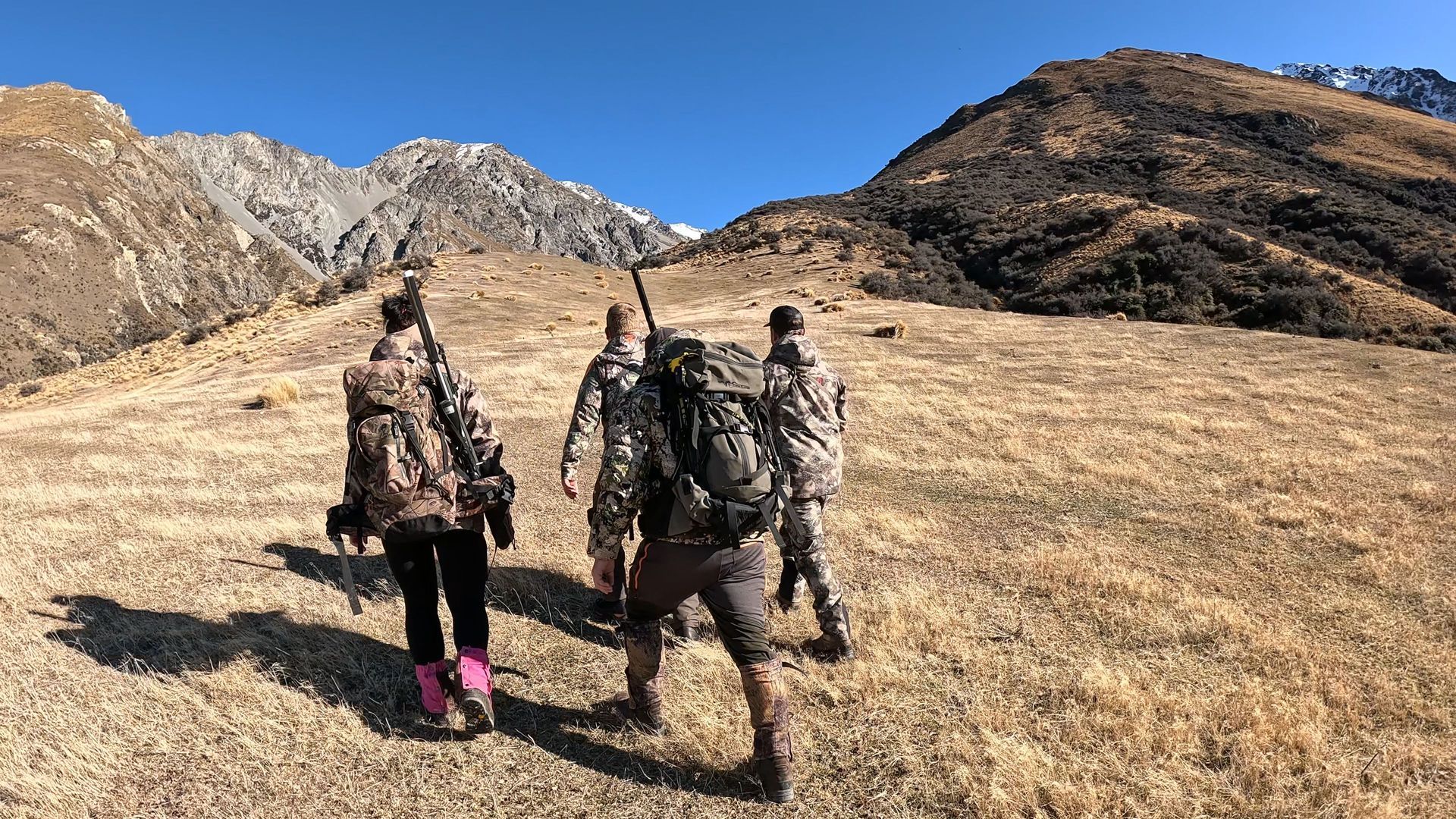 A group of people are walking up a hill in the mountains.High Country Outfitters