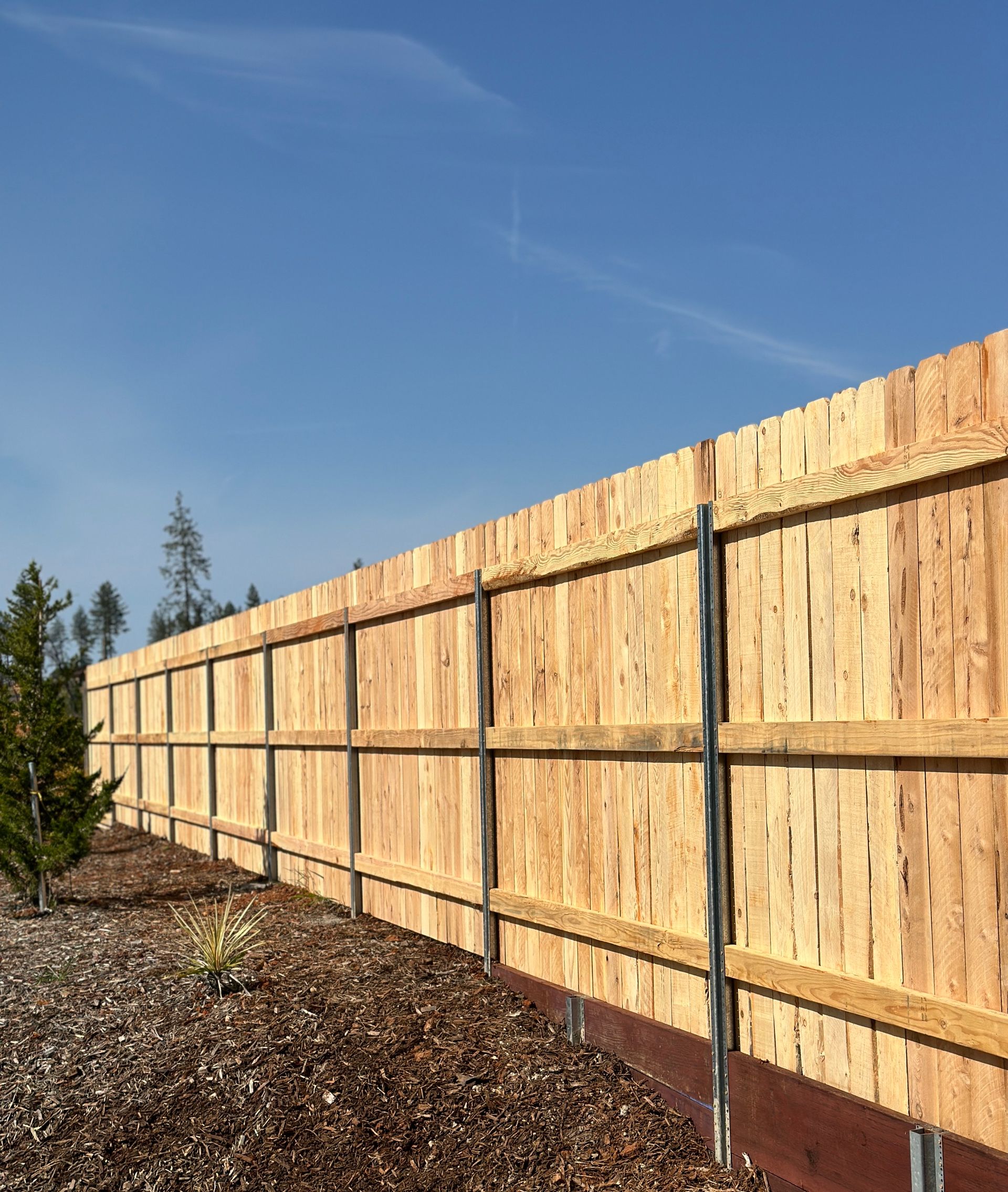 A white fence along a sidewalk in front of a house