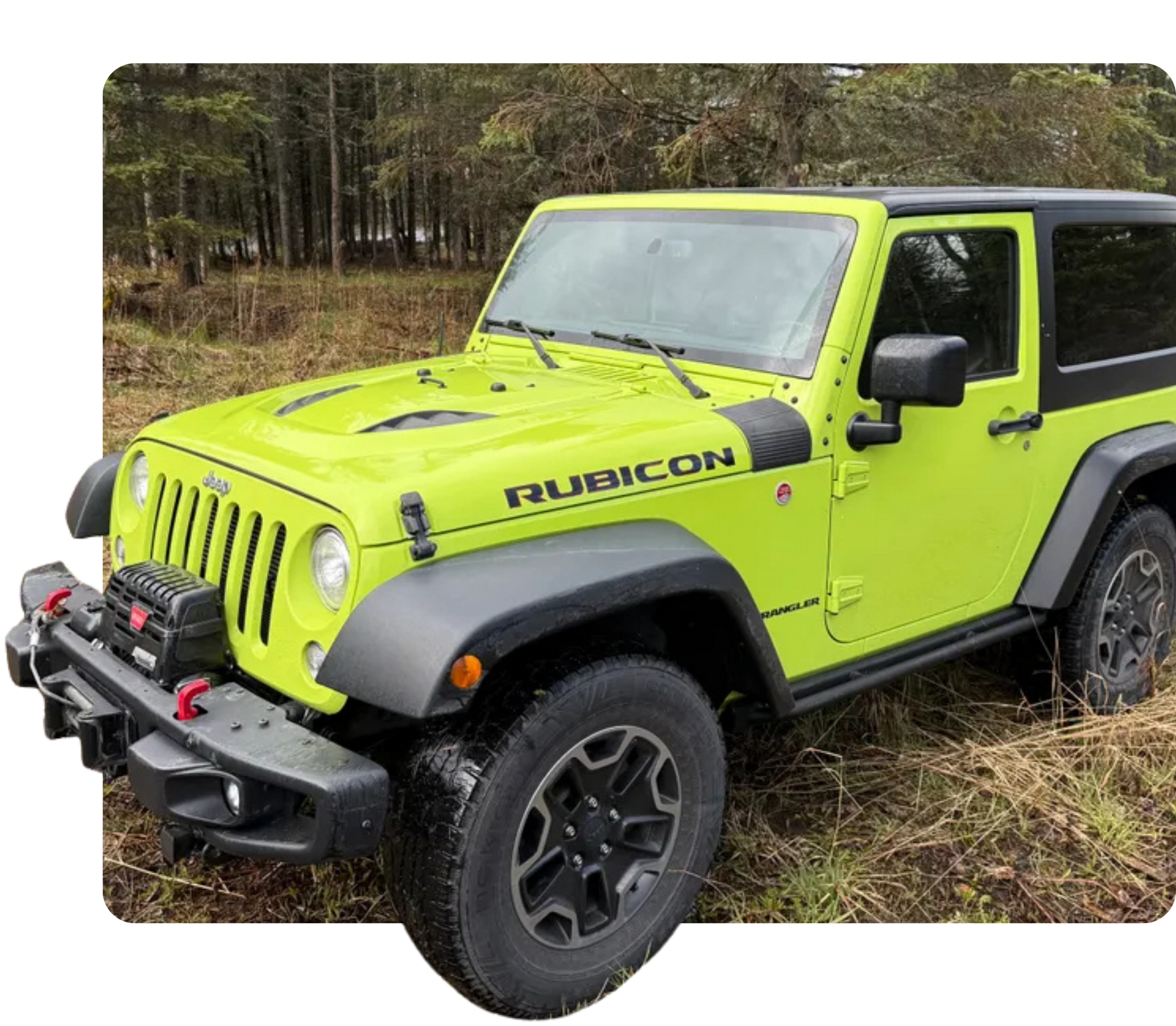 Bright lime-green Jeep Wrangler Rubicon parked on grass near a wooded area