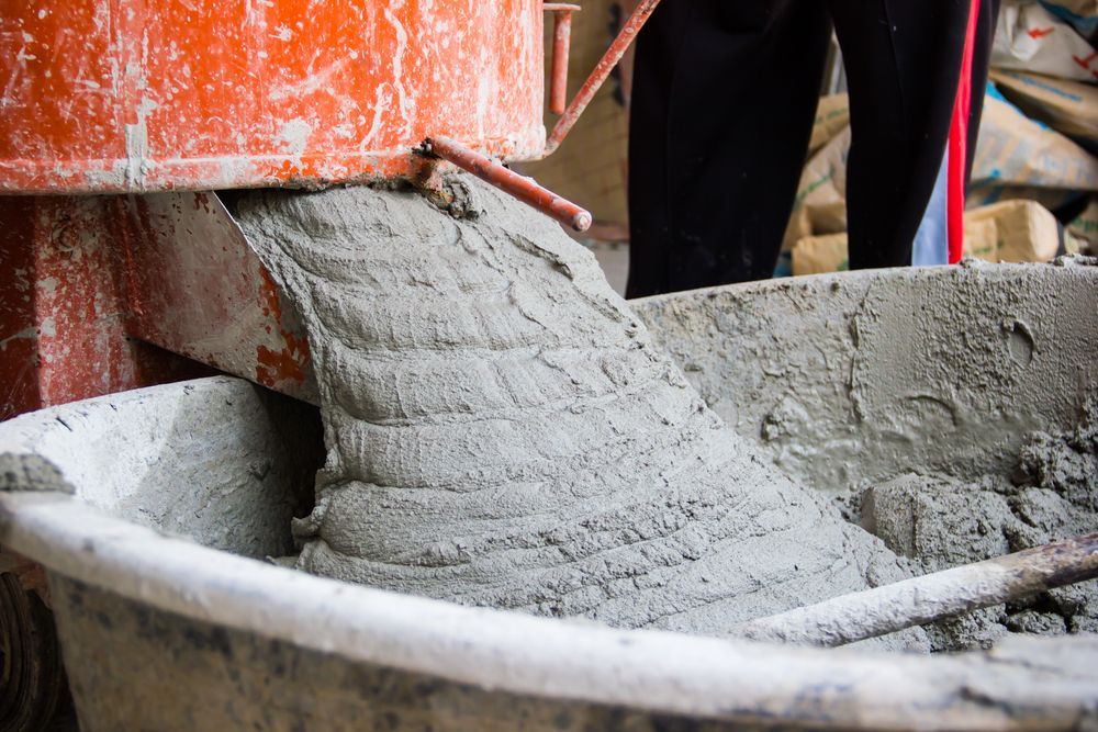 Cement Mixer Pouring Wet Concrete Into a Wheelbarrow — DGW Wholesale Timber & Hardware in Maitland, NSW