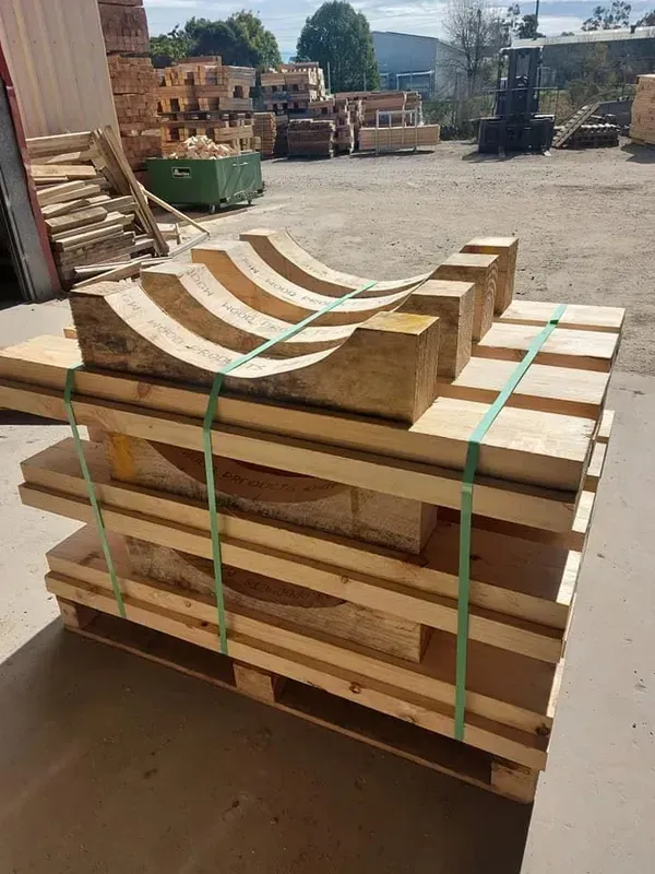 Wooden Arches and Planks Secured on A Pallet with Green Straps — DGW Wholesale Timber & Hardware in Beresfield, NSW