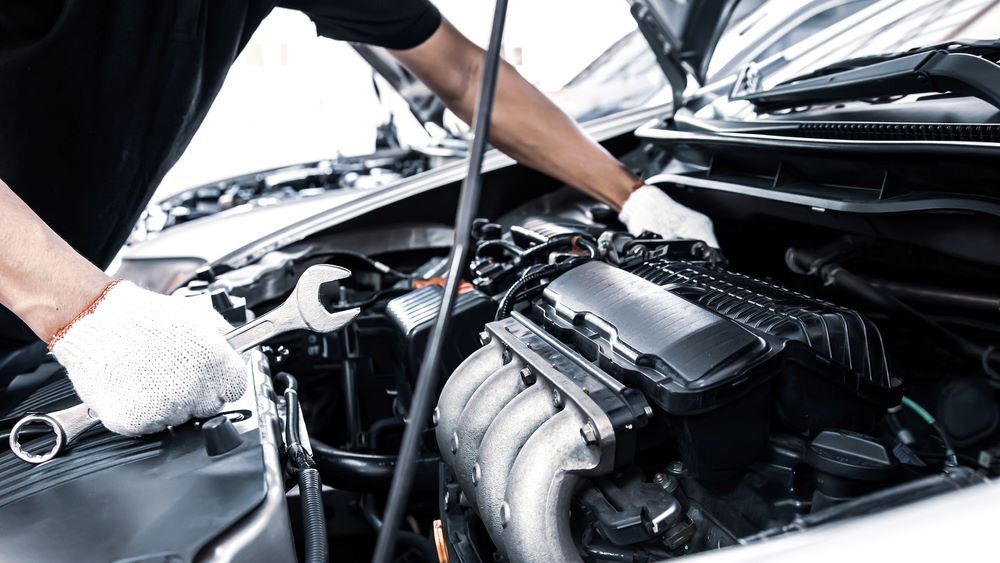 A Person is Working on a Car Engine With a Wrench — Skazas Automotive In Cardiff, NSW