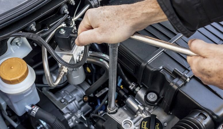 A Person is Working on a Car Engine With a Wrench — Skazas Automotive In Cardiff, NSW