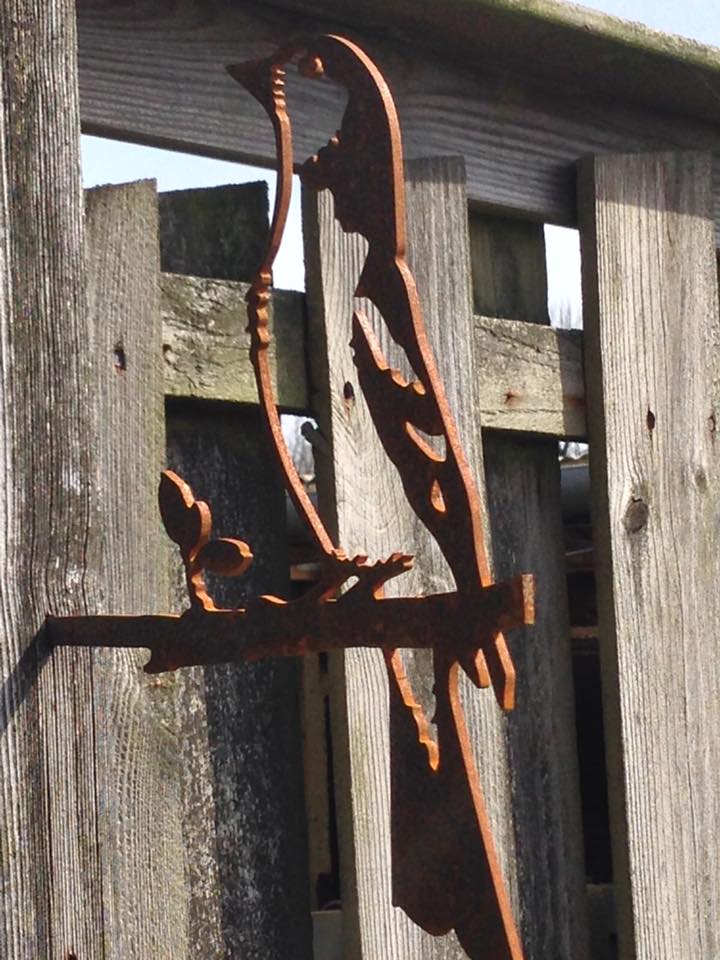 Een houten hek met daarop een sculptuur van een vogel