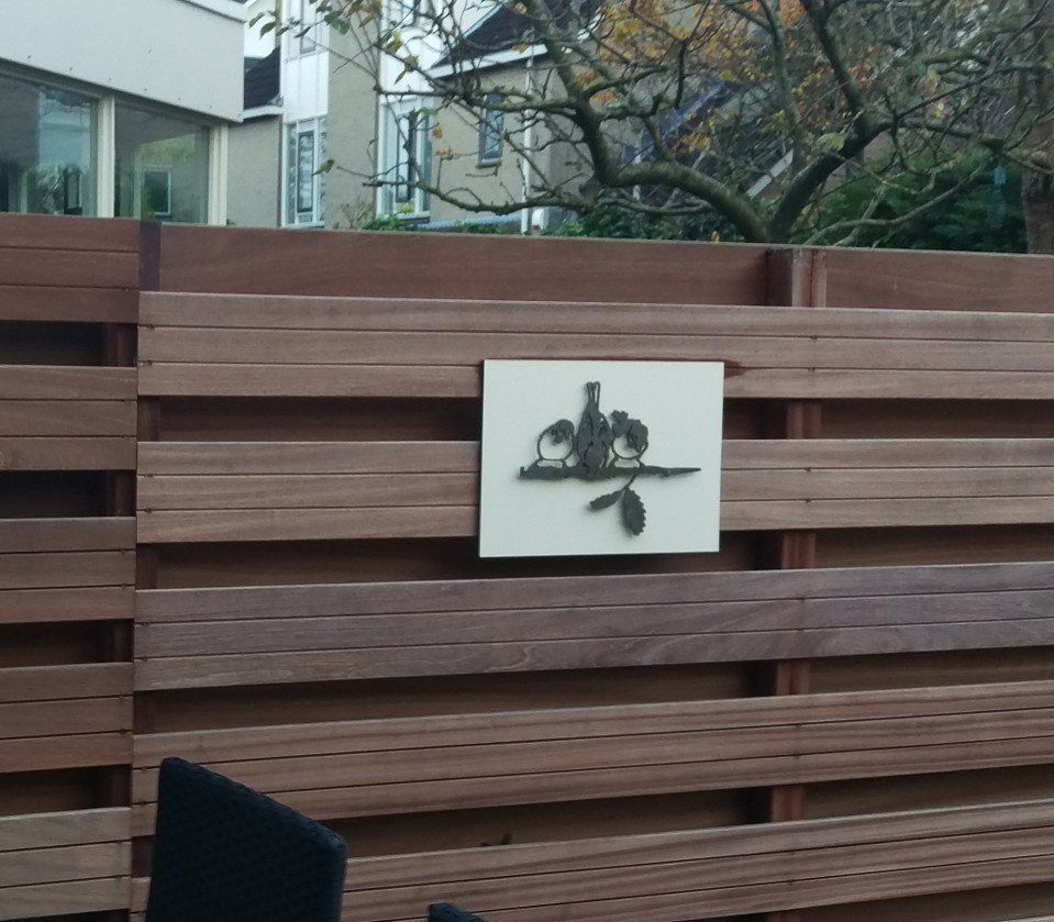 Een houten hek met een wit bord erop