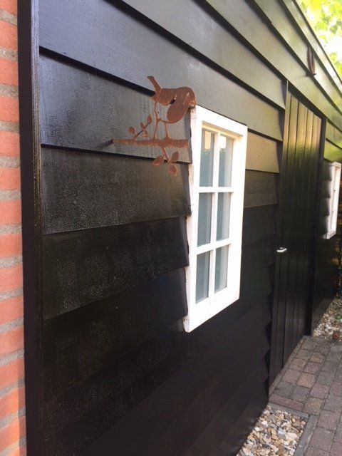 Een zwart gebouw met een wit raam aan de zijkant