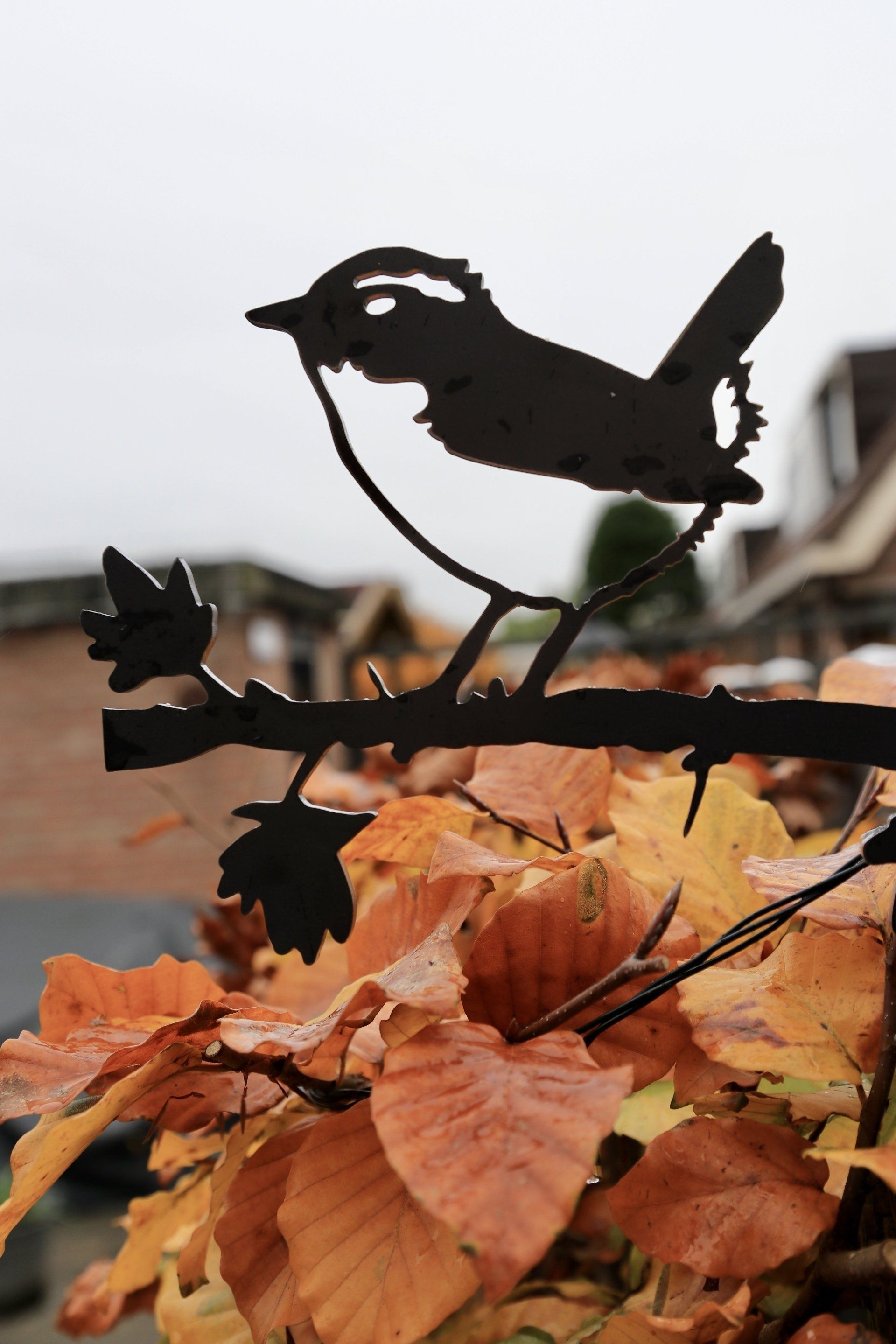 Een silhouet van een vogel die op een tak met bladeren zit