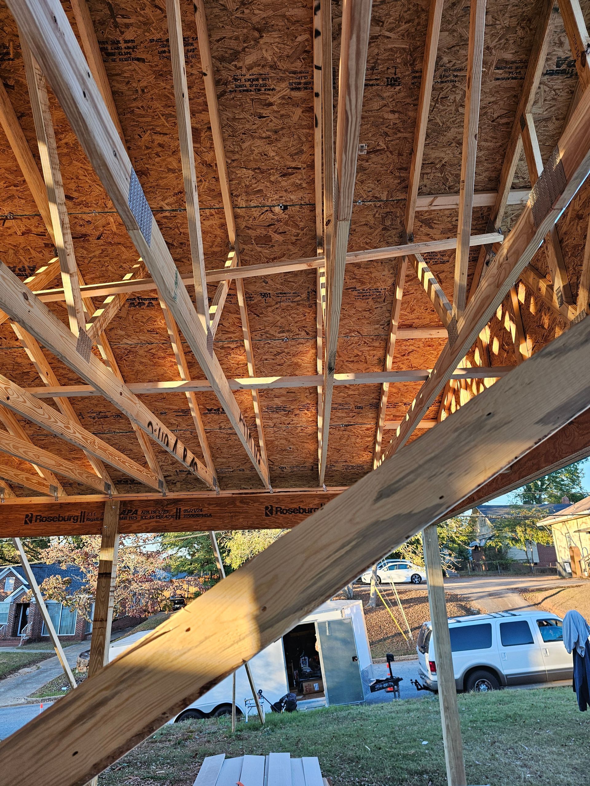 Wooden roof framing of a house under construction; a sunny day.