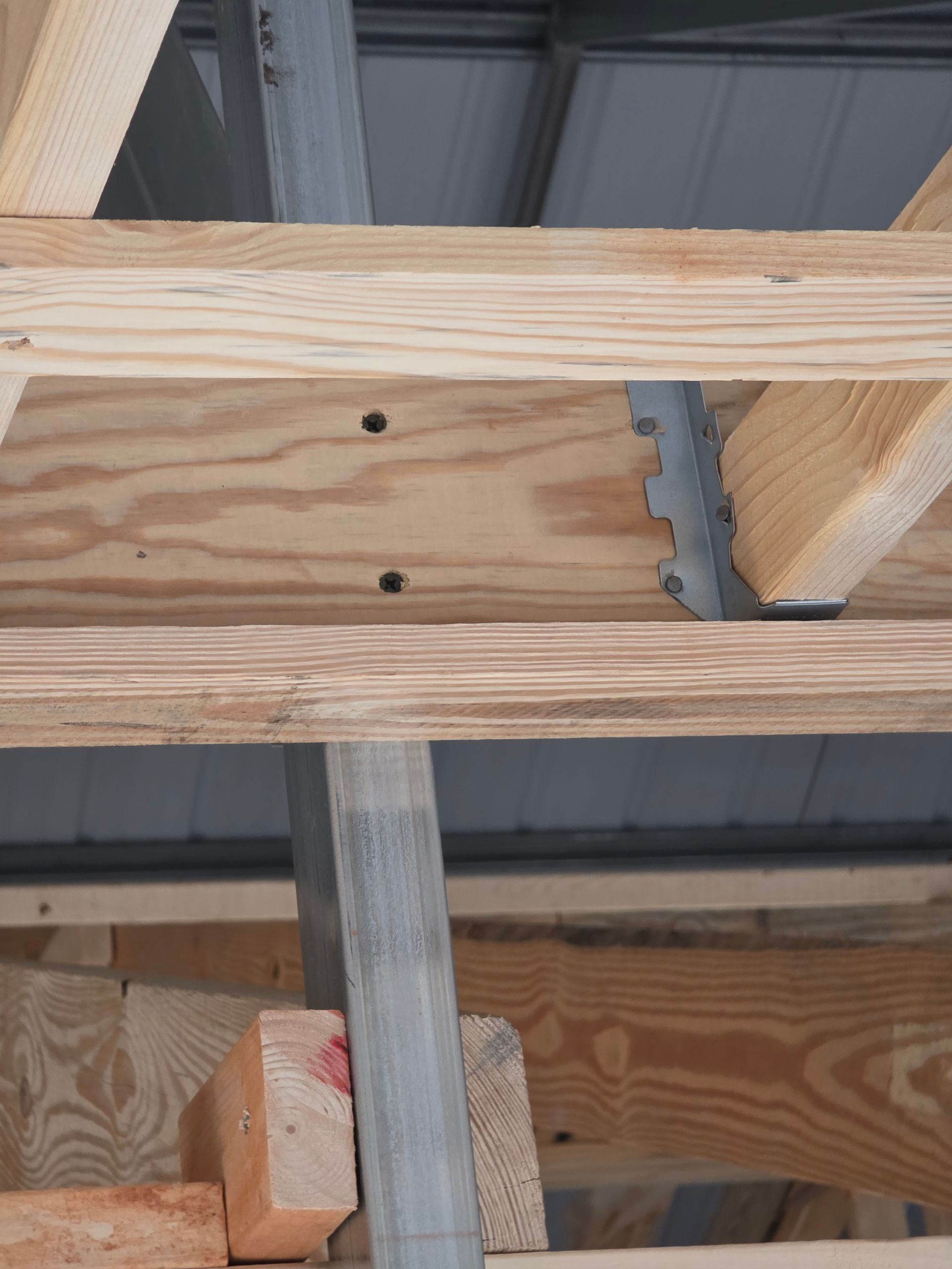 Wooden rafters with metal roof supports and fasteners.
