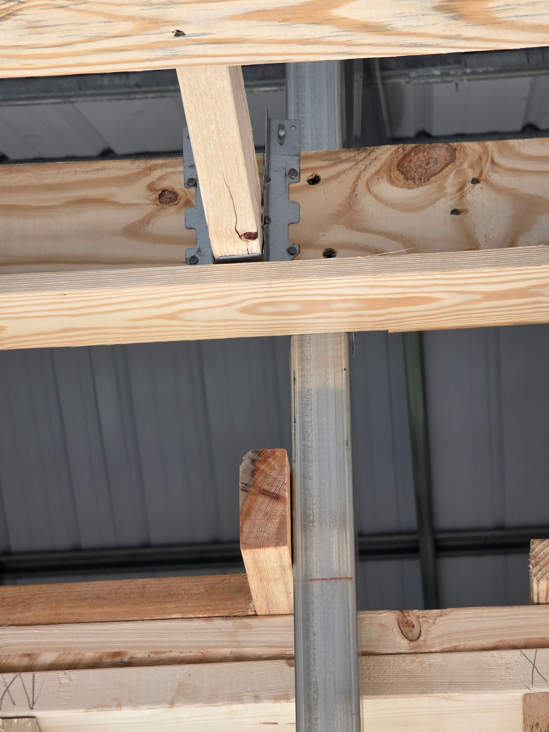 Wooden roof beams connected to metal support column with metal connector.