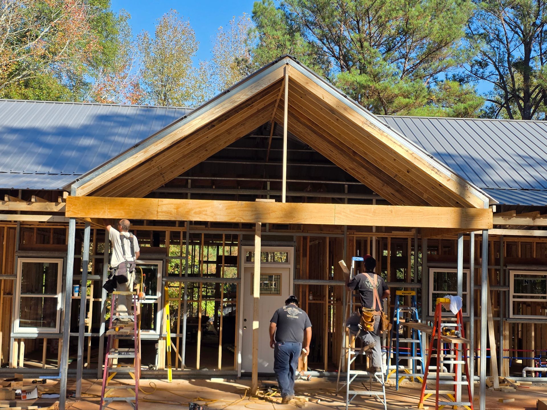 Construction workers building a house, framing the front porch area.