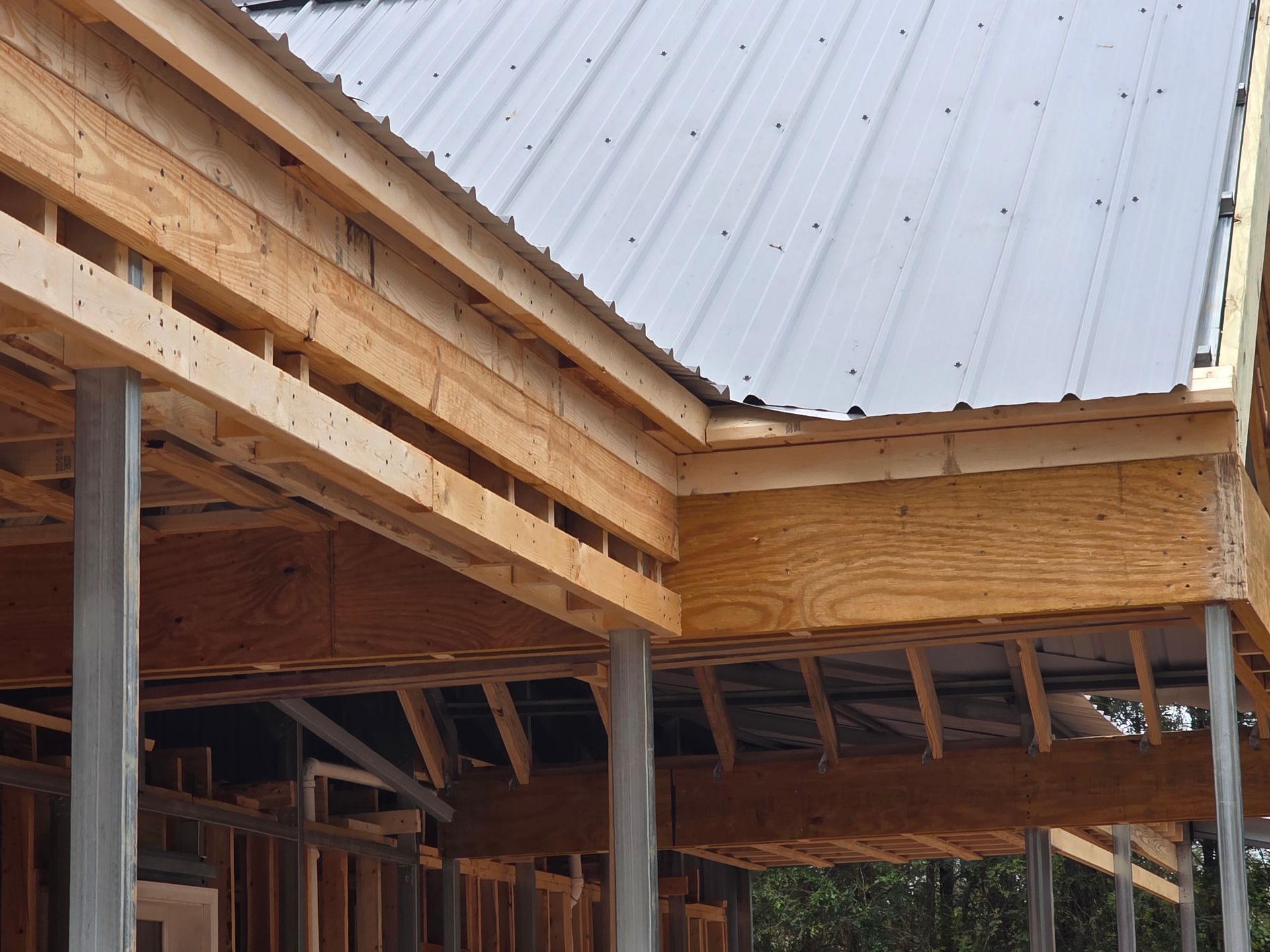 Wooden structure with a metal roof under construction.