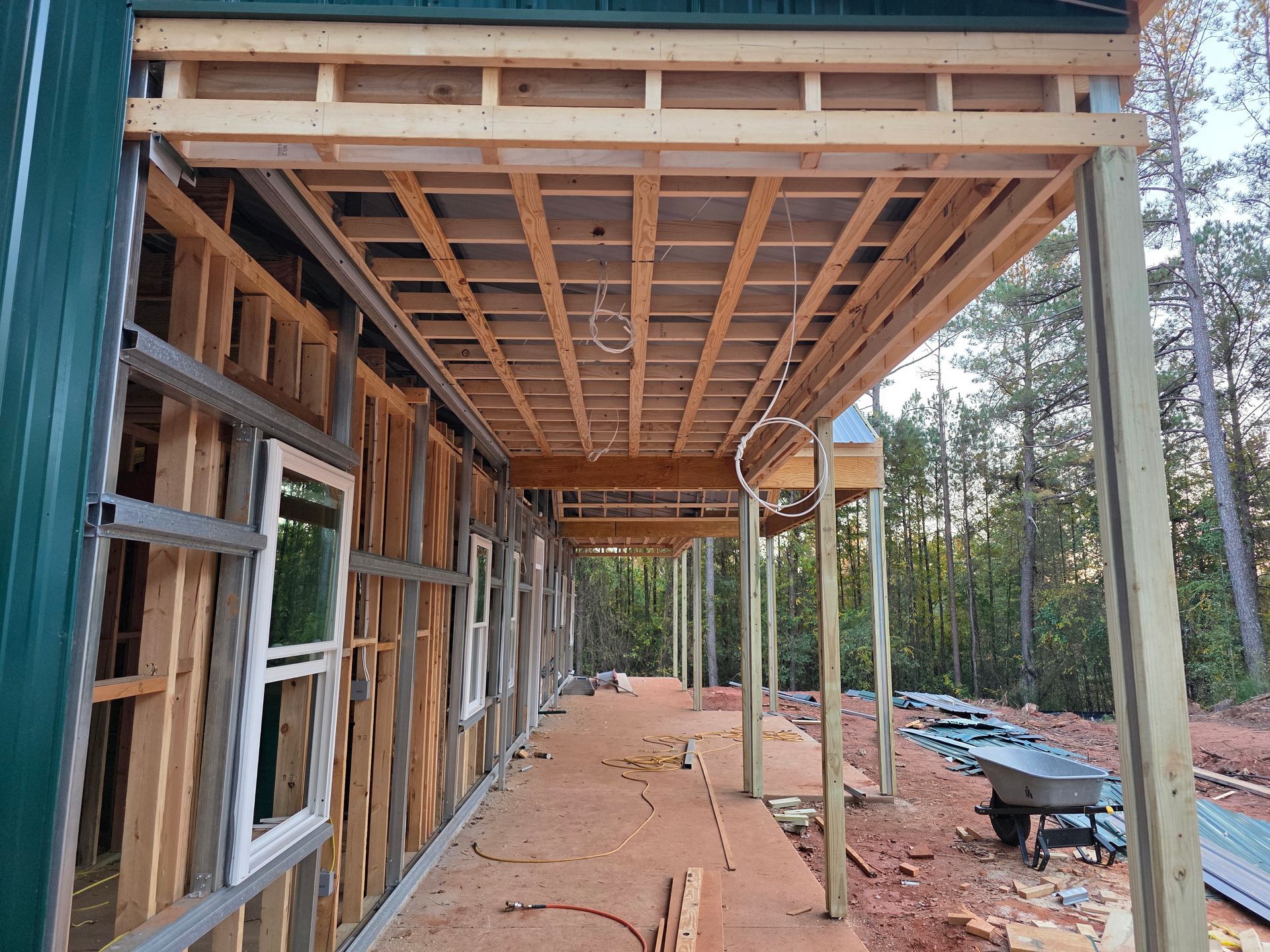 Construction site with a covered porch under construction; framing visible.