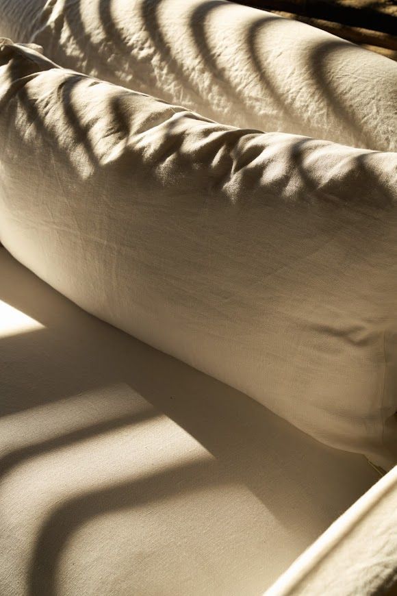 White couch cushions with striped shadows from sunlight.
