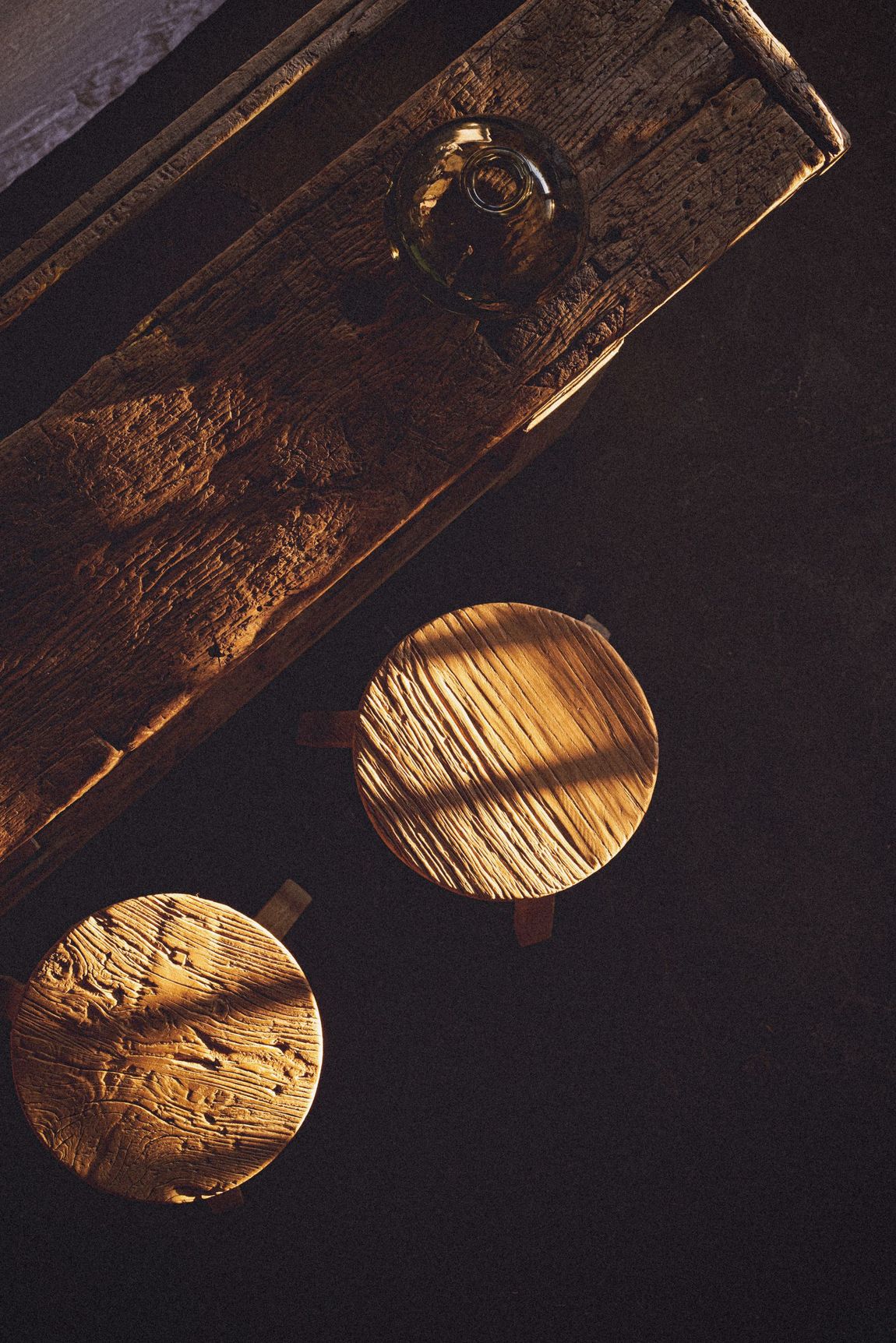 Wooden dowels and a plank, with natural light and shadows.