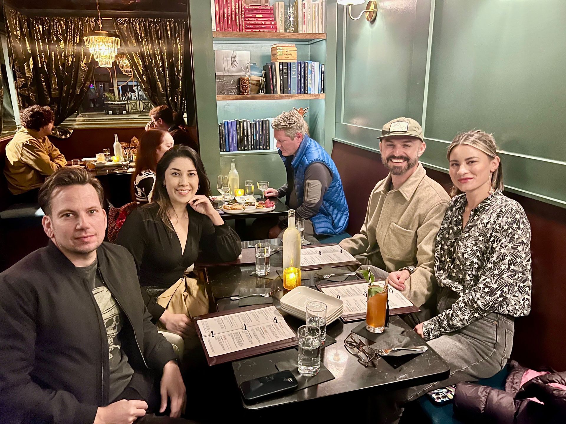 A group of friends enjoying food and drinks at Kin Lounge