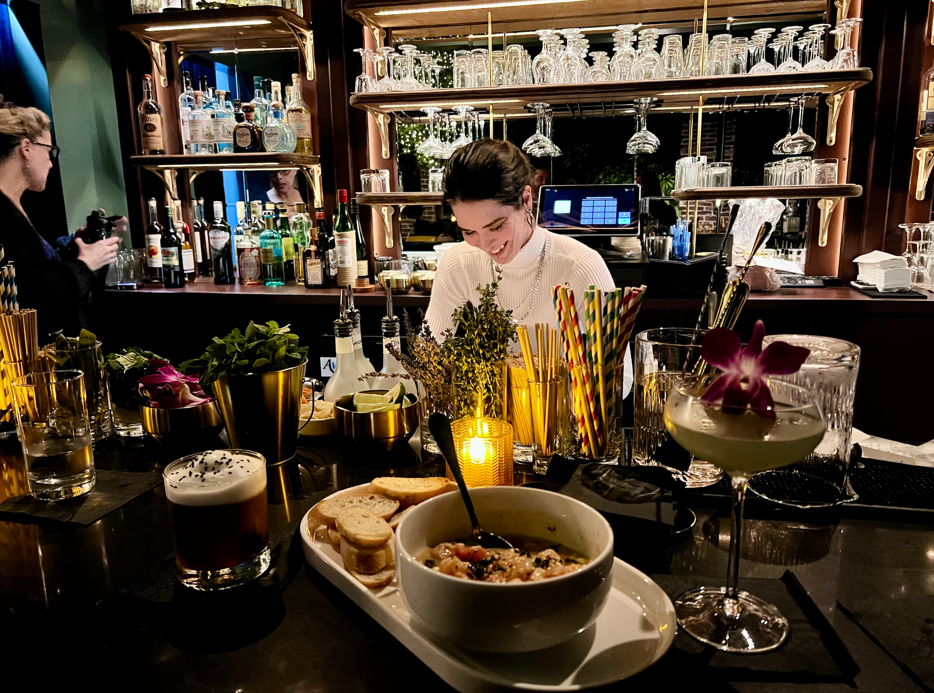 Happy bartender mixing drinks behind the bar at Kin Bar