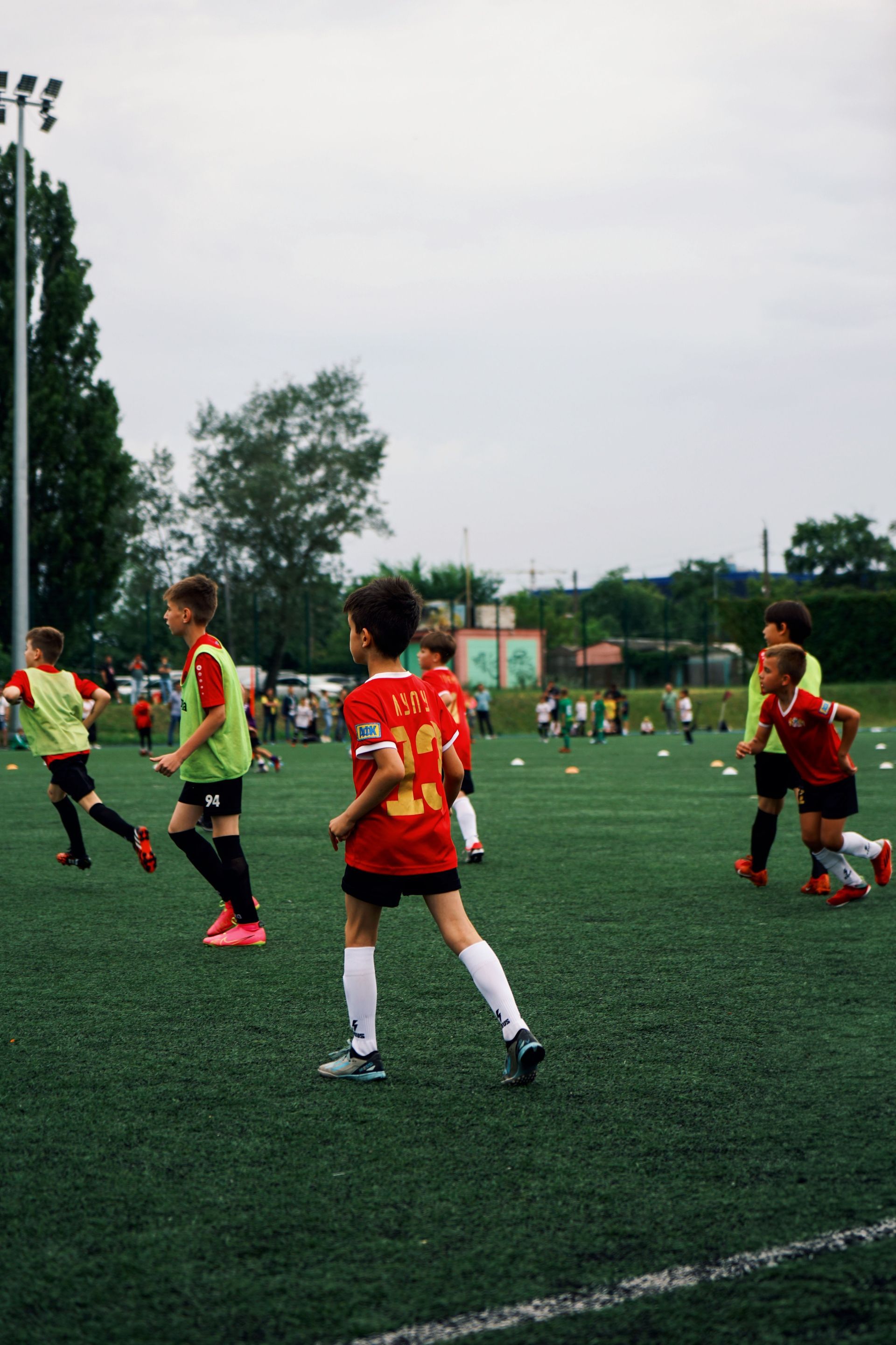Soccer players in red and neon jerseys on a green field during a match