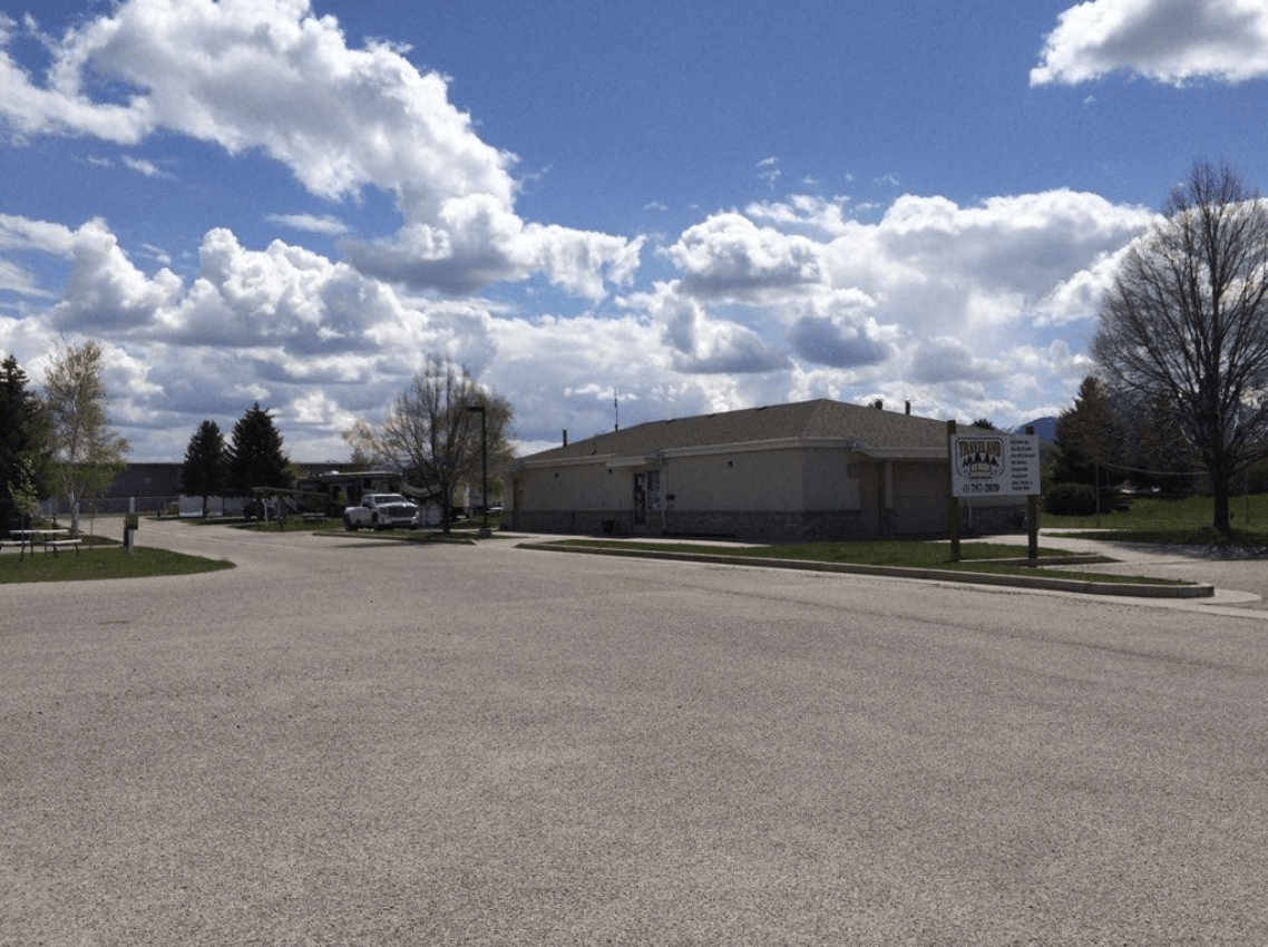 Front of a mobile home with trucks in the driveway at South Springville Mobile Home Park