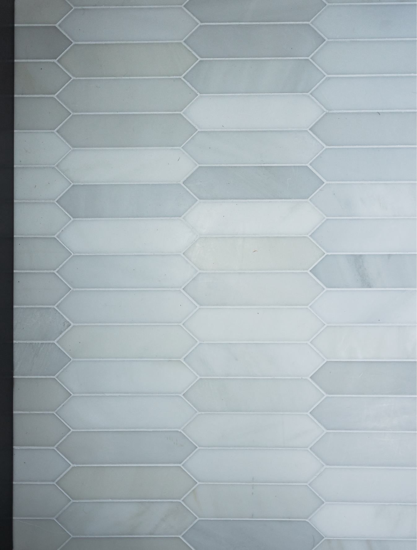 White and light gray hexagon tile pattern on a wall