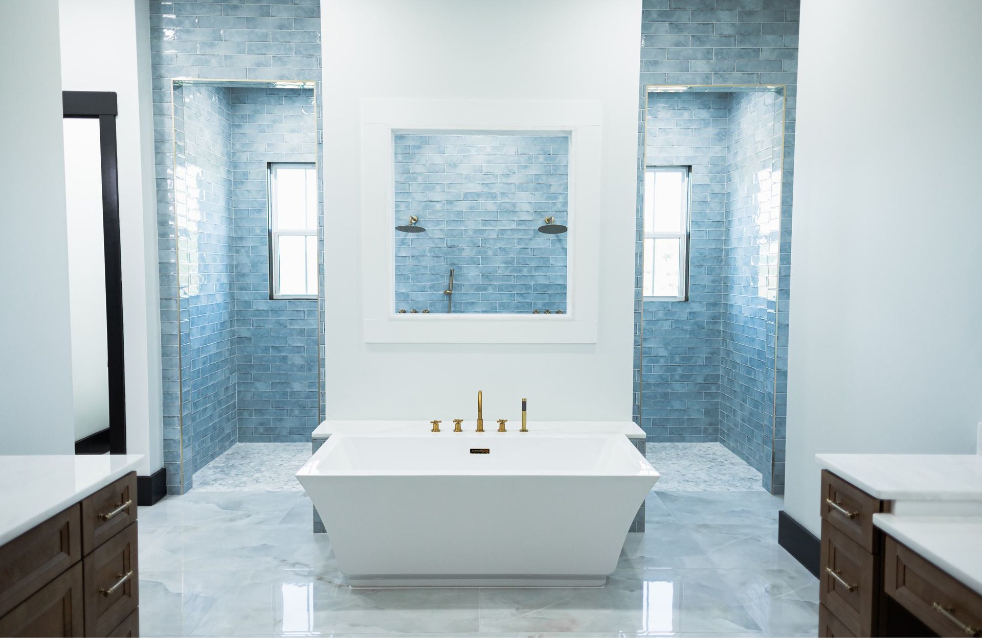 Modern bathroom with freestanding tub, blue tile walls, and a large mirror
