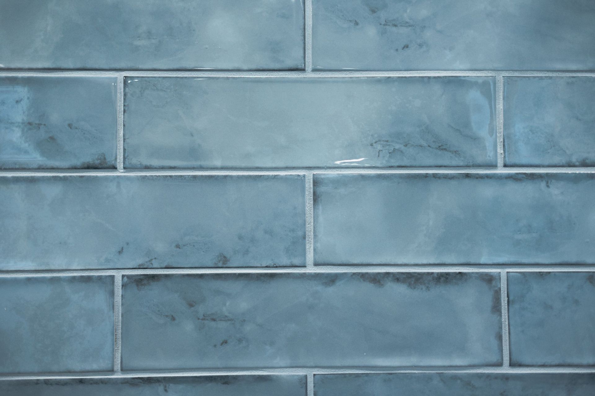 Blue painted brick wall with horizontal mortar lines and weathered texture
