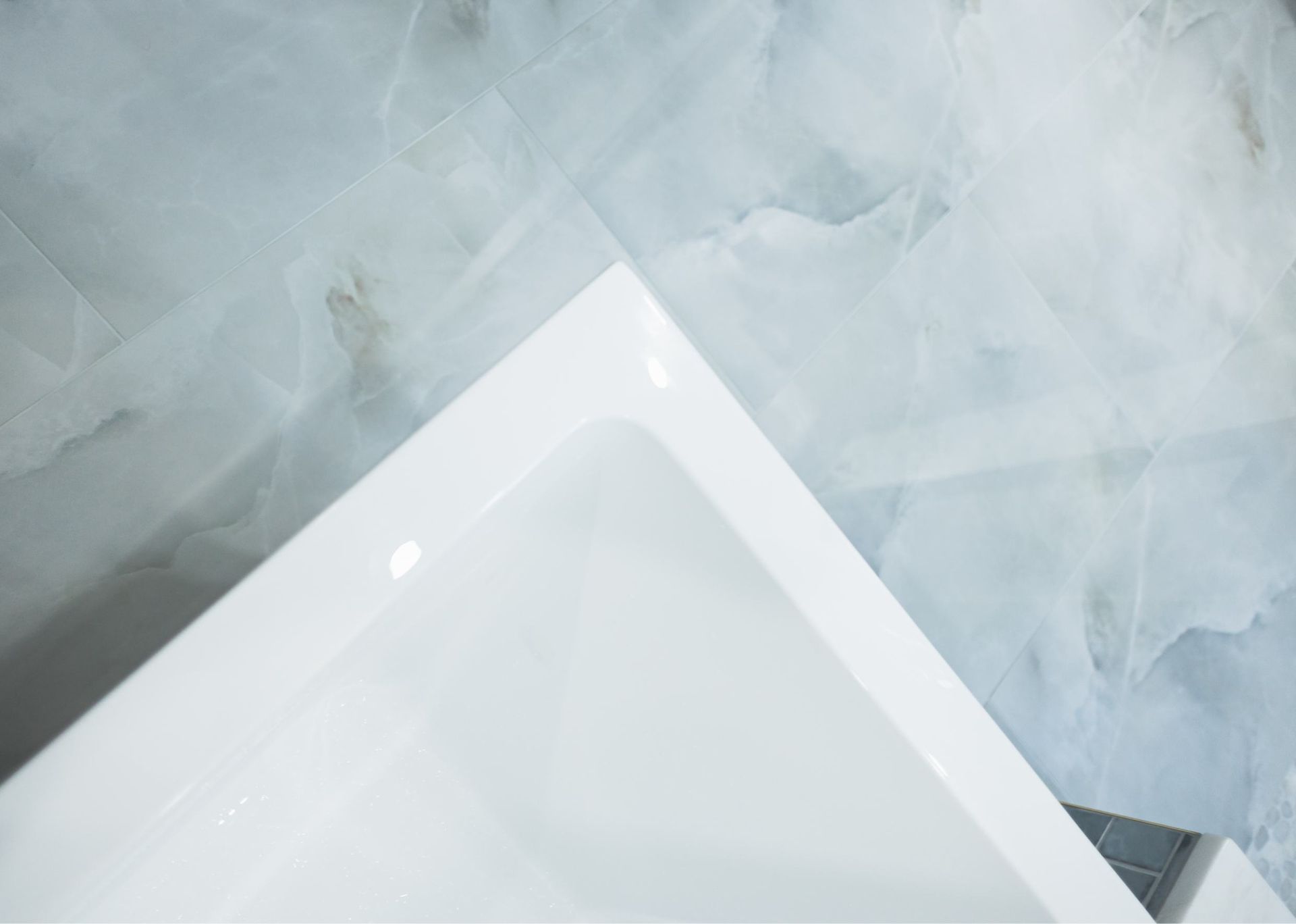 White tablet on a pale blue textured surface, viewed from above