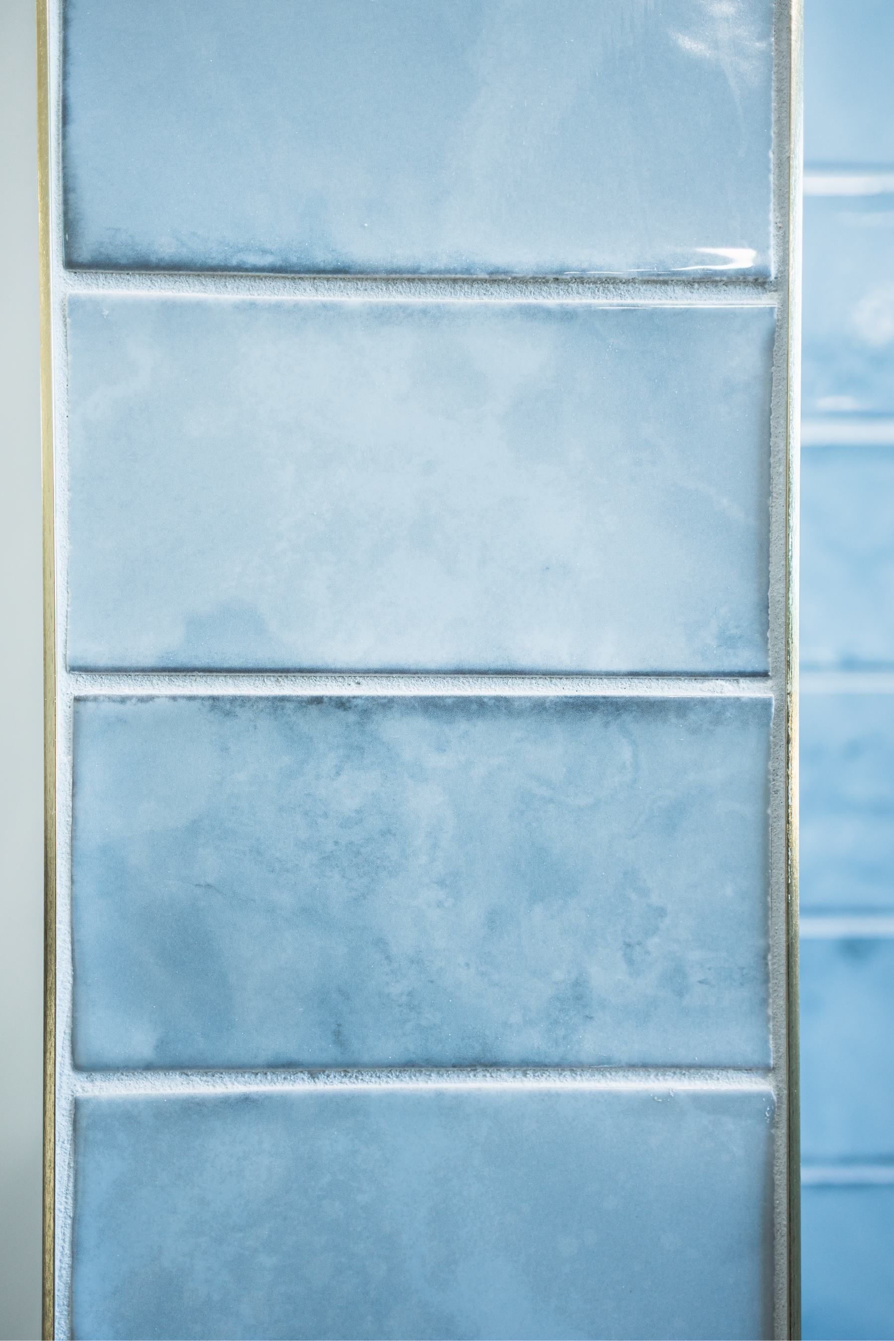 Blue glazed ceramic tiles with white grout lines on a wall