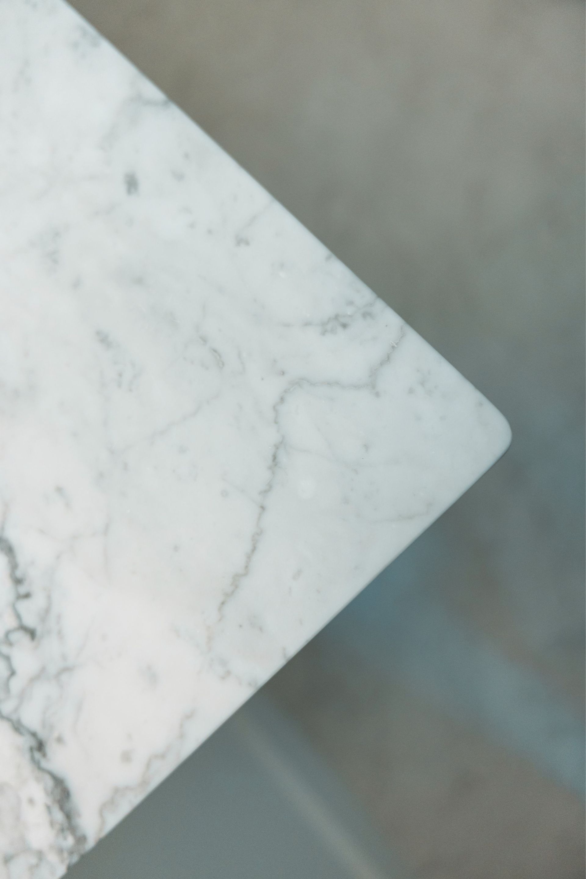 White marble tabletop corner against a gray floor background.