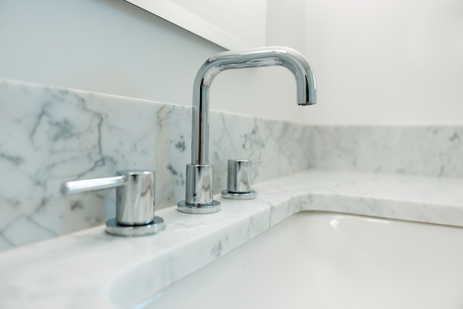 Modern bathroom sink with chrome faucet and marble countertop
