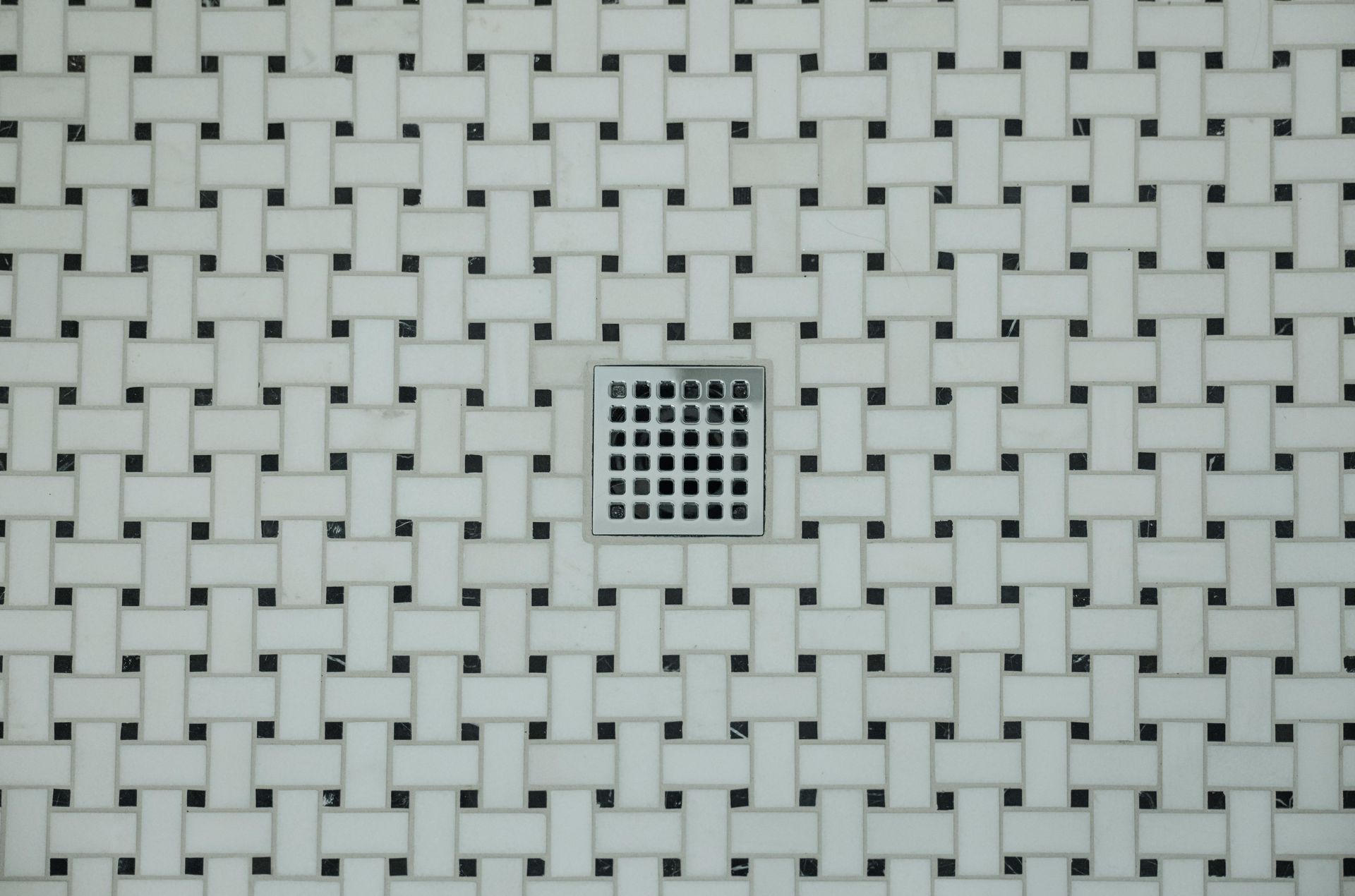 White woven plastic mat with a small square black-and-white grid detail in the center.
