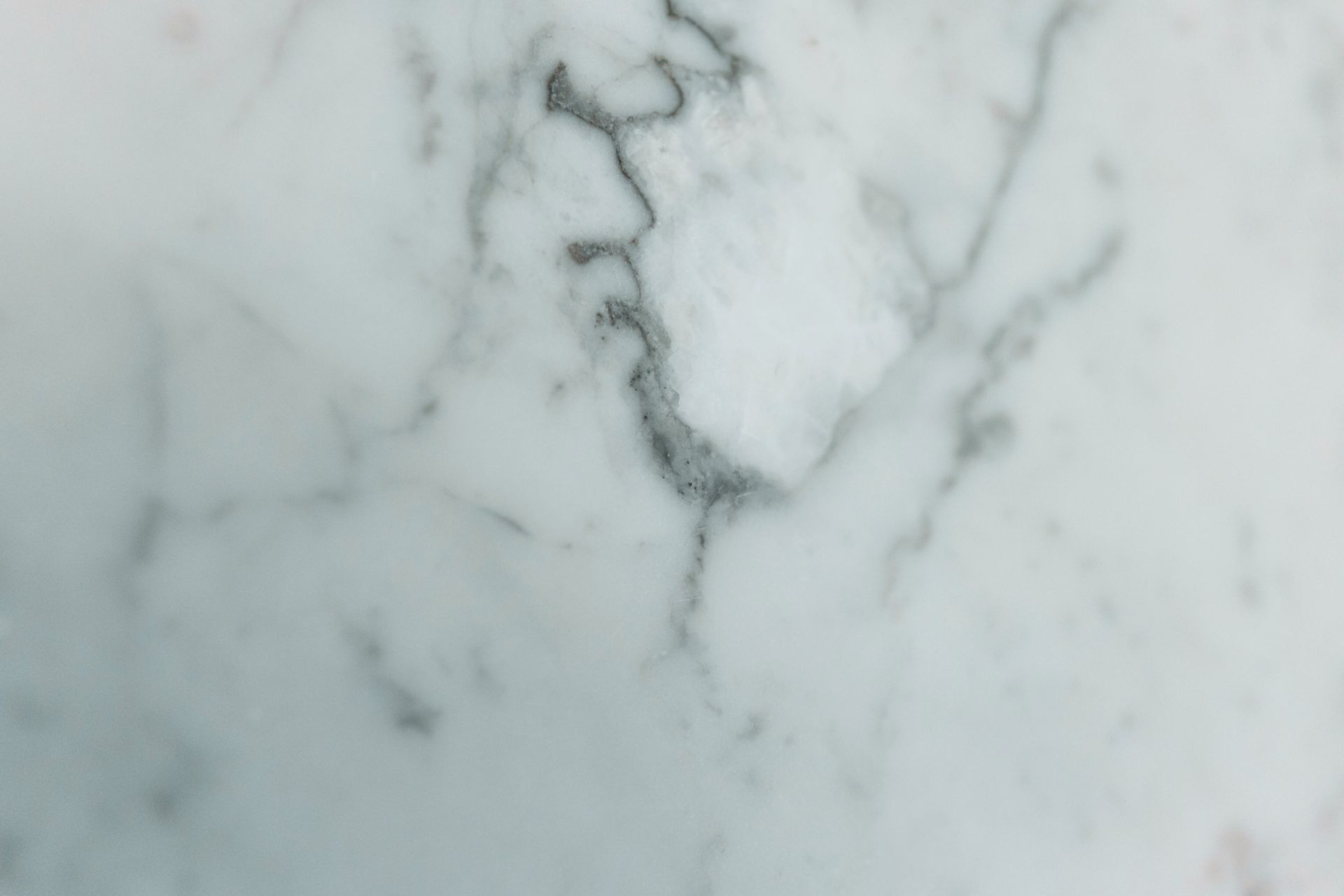White marble surface with subtle gray veins and a darker central crack pattern