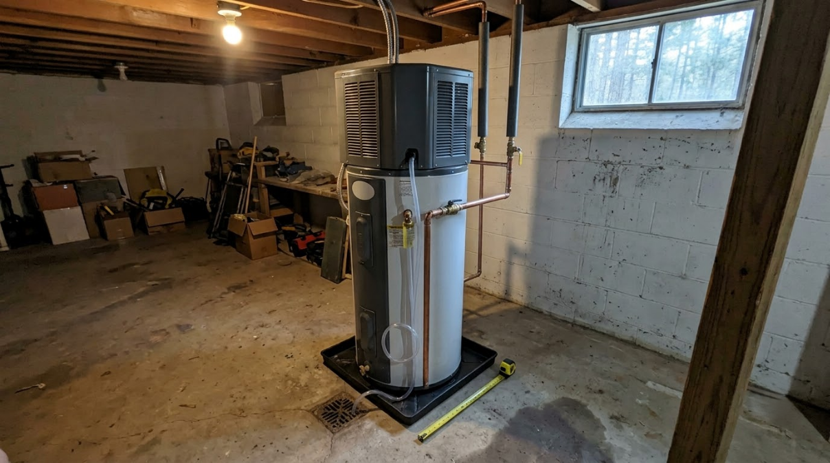 Basement room with a water heater beside a window and storage shelves in the background