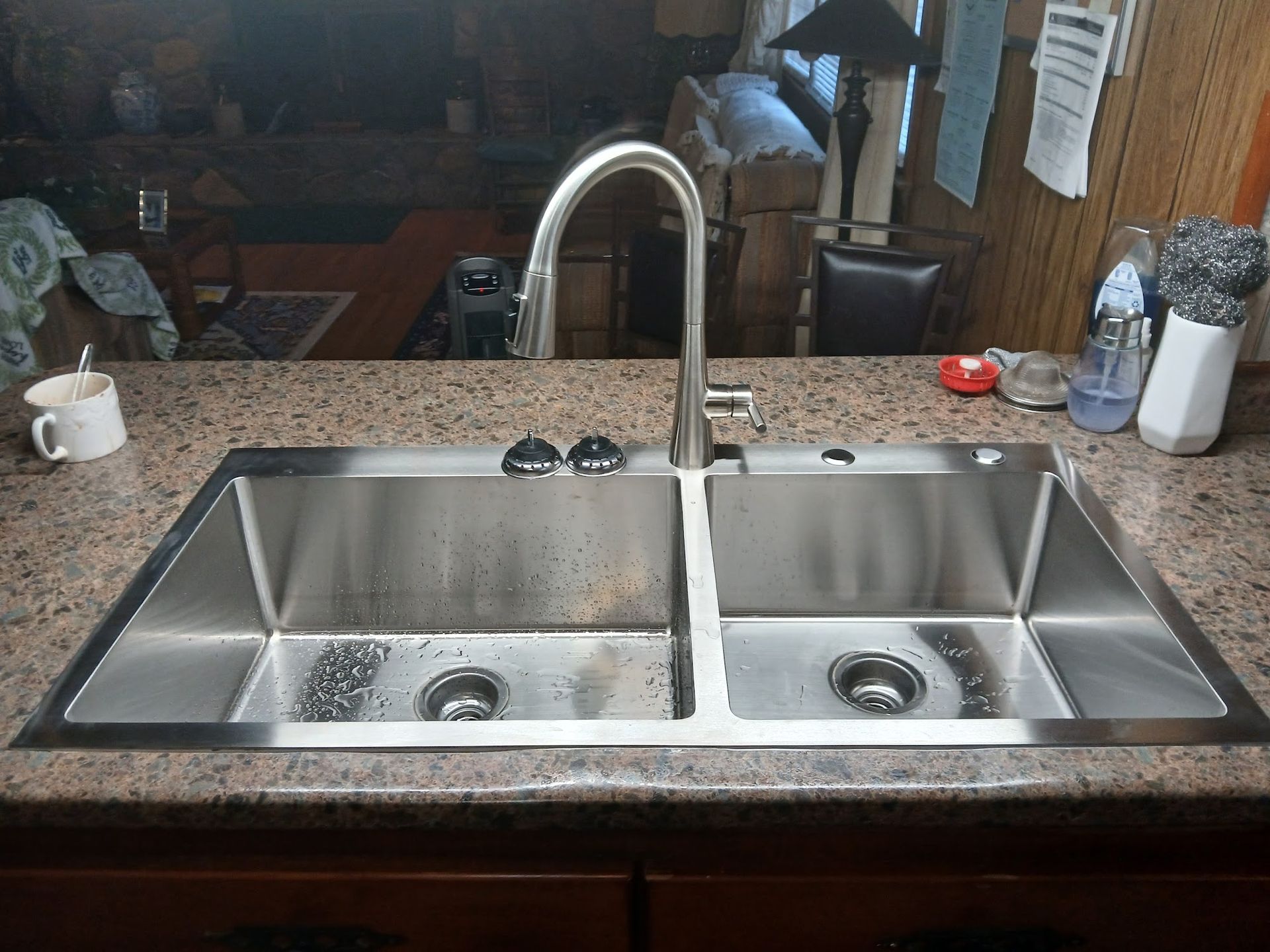 Double kitchen sink with arched faucet on a granite countertop