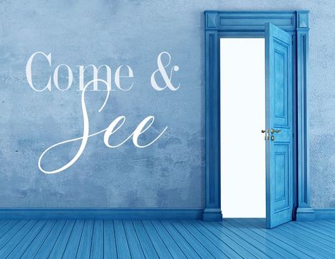 A blue door stands open inviting visitors to watch our welcome video