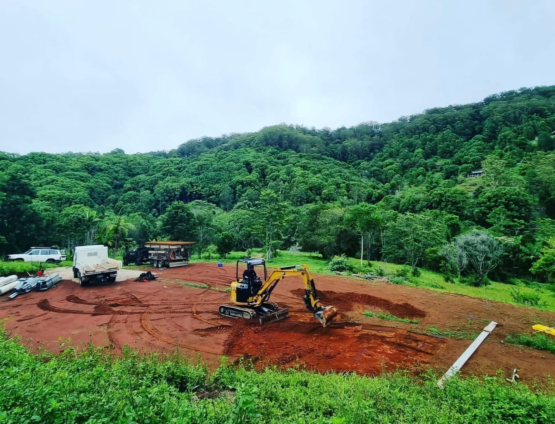 A Concrete Pump is Pouring Concrete on a Dirt Road — TJ Concreting in Northern Rivers, NSW