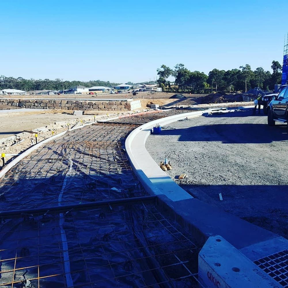 A Blue Truck is Parked on the Side of a Road Under Construction — TJ Concreting in Northern Rivers, NSW