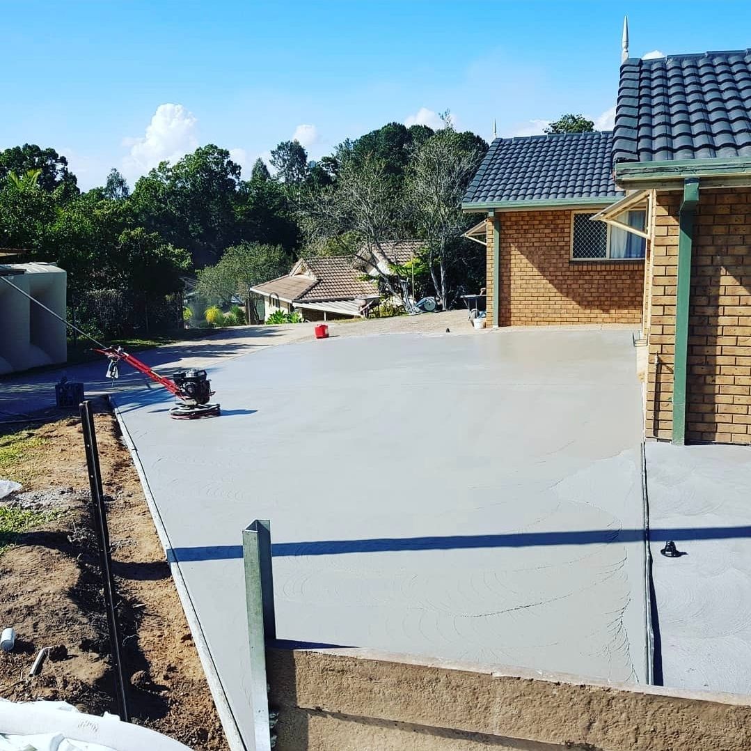 A Boat is Parked in Front of a House With a Brick Driveway — TJ Concreting in Northern Rivers, NSW