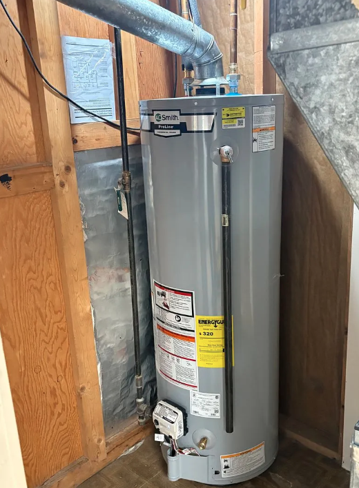 Water heater installed in a narrow utility closet with exposed wood framing and ductwork